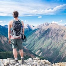 Adventurer exploring mountains, overlooking a valley