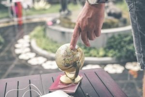 Touching a globe that is on top of a passport